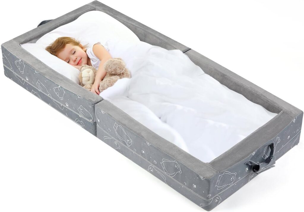 Child sleeping in a gray portable toddler travel bed with safety rails
